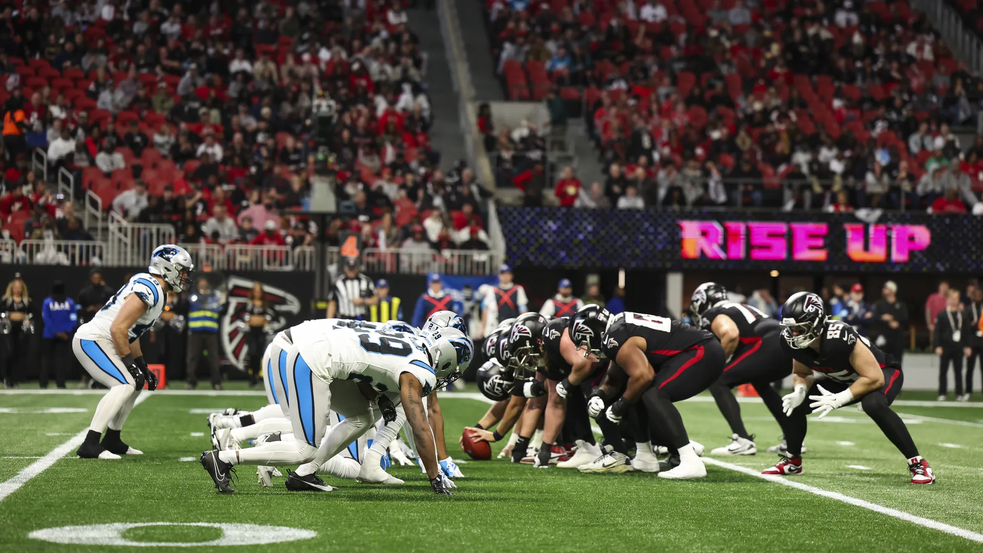 Visiting team fans clustered in a packed NFL stadium section